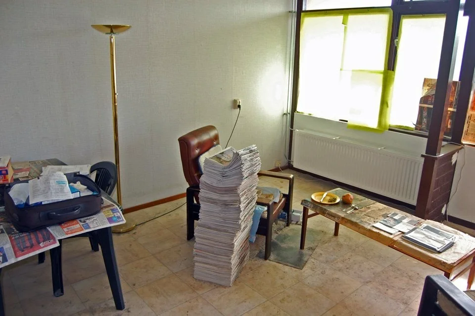 An empty room with stacked books and belongings, from the municipal funeral team archive.
